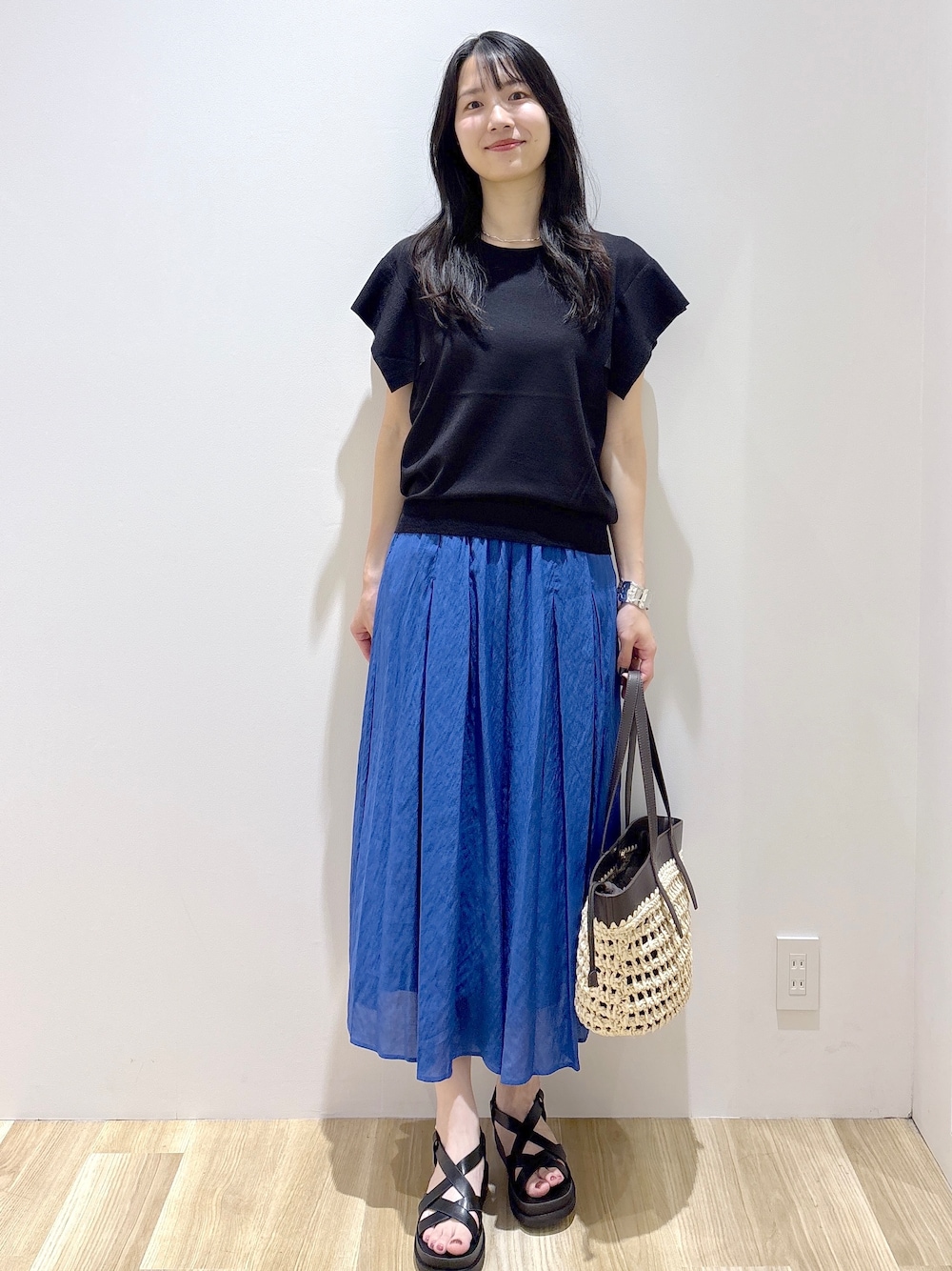 ブラック系のニット/セーター、ブルー系のその他パンツ、ブラウン系のトートバッグを着用したレディースの夏コーディネートの8枚目の写真