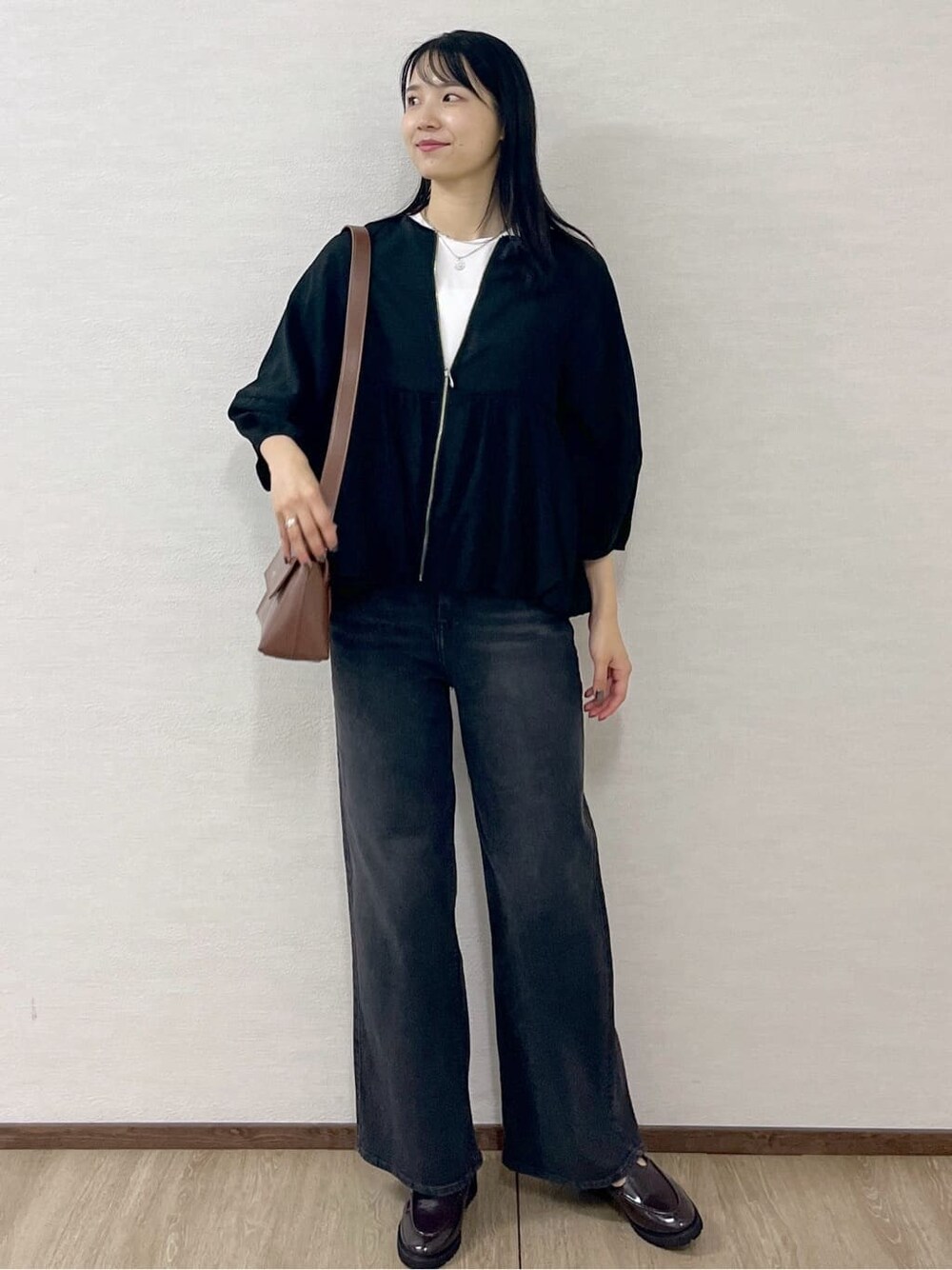 ブラック系のブルゾン、ホワイト系のTシャツ/カットソー、ブラック系のデニムパンツを着用したレディースの夏コーディネートの2枚目の写真