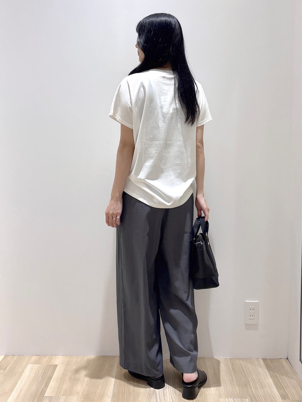 ホワイト系のTシャツ/カットソー、グレー系のその他パンツ、ブラック系のトートバッグを着用したレディースの夏コーディネートの4枚目の写真