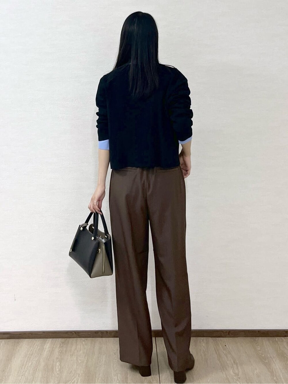 ブラック系のカーディガン/ボレロ、ブルー系のシャツ/ブラウス、ブラウン系のその他パンツを着用したレディースの秋コーディネートの4枚目の写真