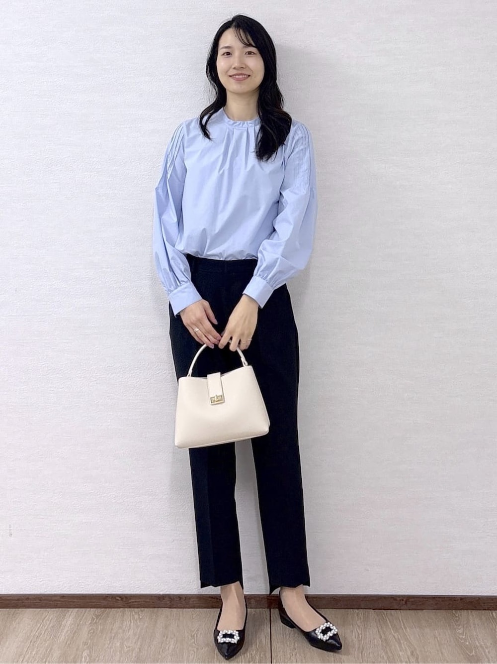 ブルー系のシャツ/ブラウス、ブラック系のその他パンツ、ホワイト系のハンドバッグを着用したレディースの冬コーディネートの2枚目の写真