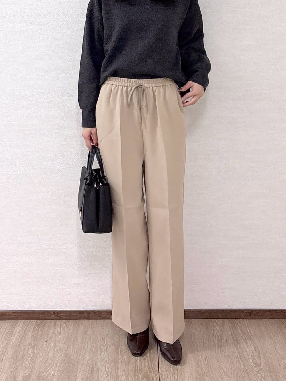 グレー系のニット/セーター、ベージュ系のその他パンツ、ブラック系のトートバッグを着用したレディースの冬コーディネートの7枚目の写真
