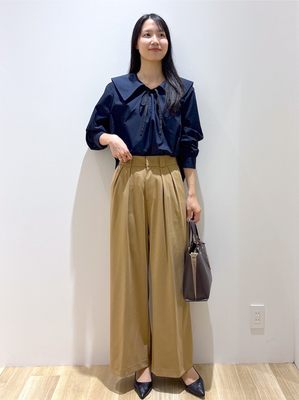 ブルー系のシャツ/ブラウス、イエロー系のその他パンツ、ブラウン系のトートバッグを着用したレディースの秋コーディネートの2枚目の写真