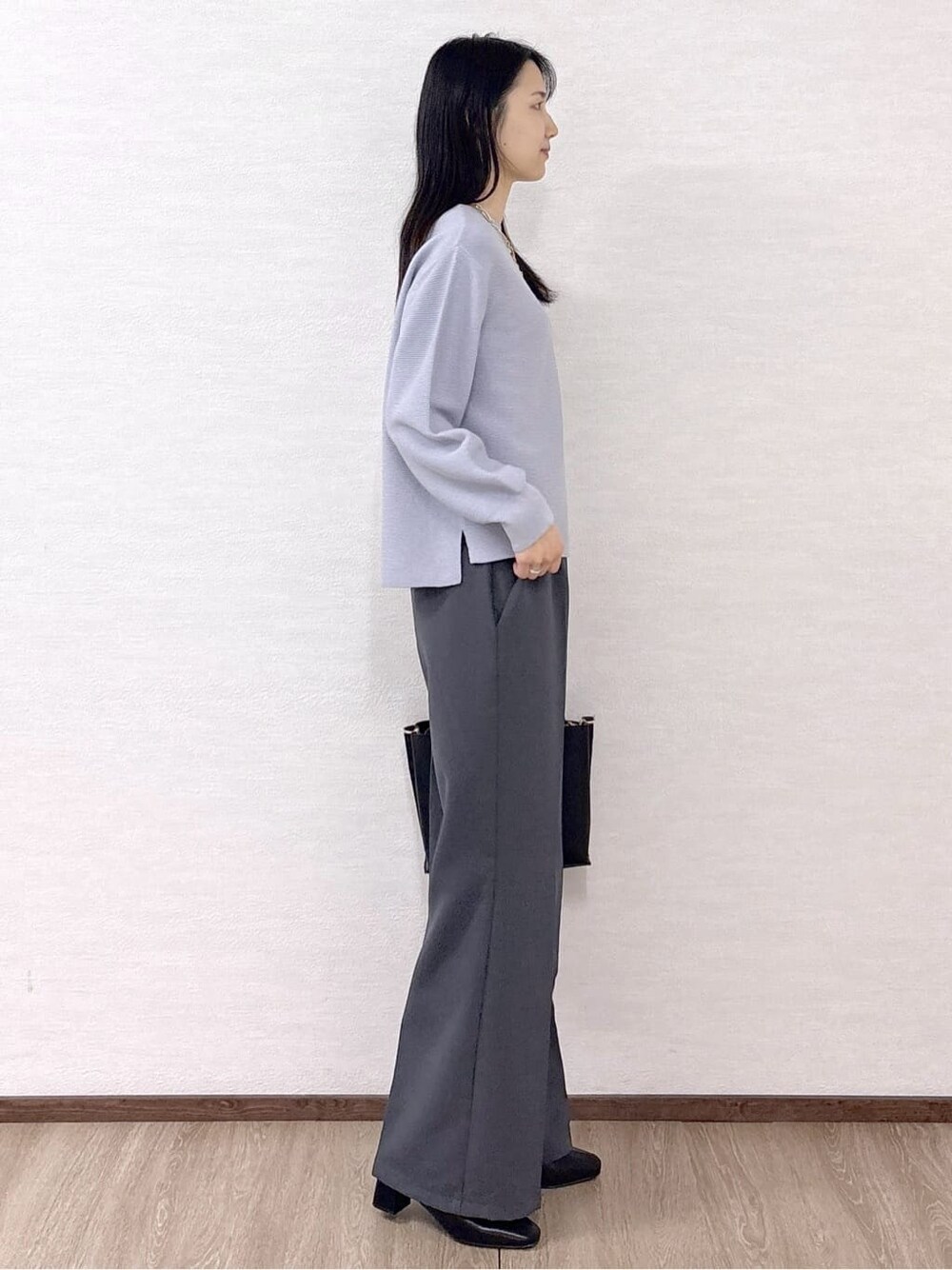 ブルー系のニット/セーター、グレー系のその他パンツ、ブラック系のトートバッグを着用したレディースの冬コーディネートの5枚目の写真