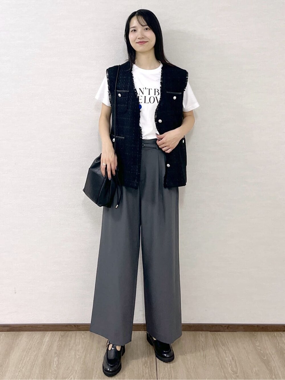 ブラック系のベスト、ホワイト系のTシャツ/カットソー、グレー系のその他パンツを着用したレディースの秋コーディネートの8枚目の写真