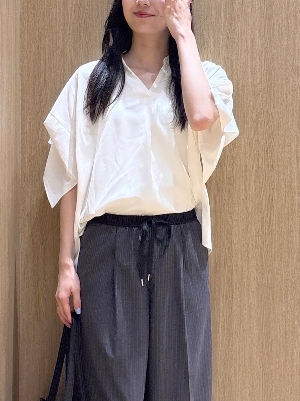 ホワイト系のシャツ/ブラウス、ブラック系のパンプスを着用したレディースの夏コーディネートの6枚目の写真
