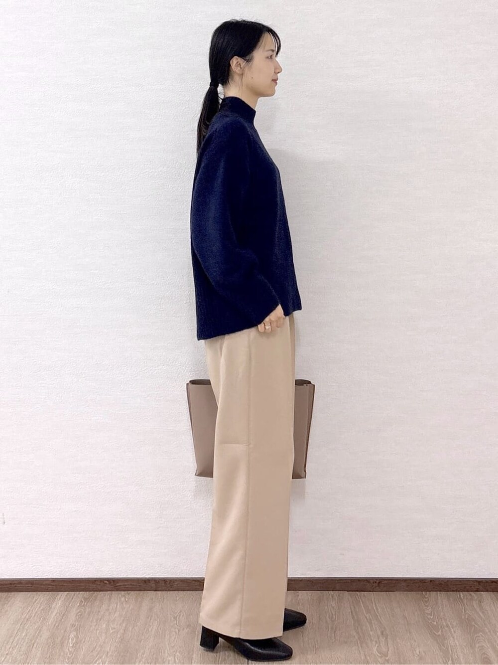 ブルー系のニット/セーター、ベージュ系のその他パンツ、ベージュ系のトートバッグを着用したレディースの冬コーディネートの5枚目の写真