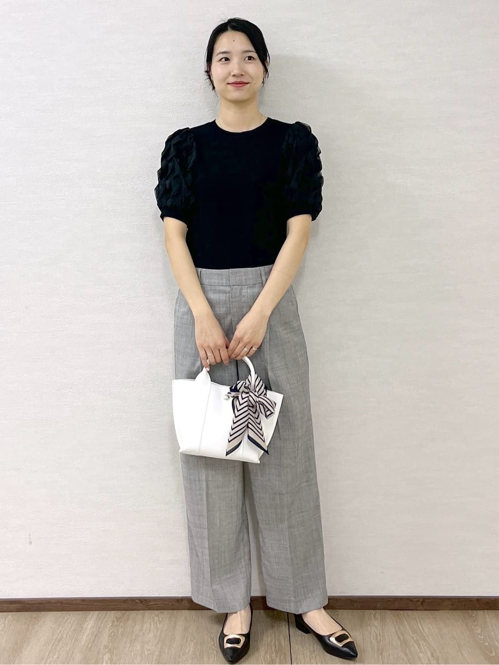 ブラック系のTシャツ/カットソー、グレー系のその他パンツ、ホワイト系のトートバッグを着用したレディースの春コーディネートの10枚目の写真