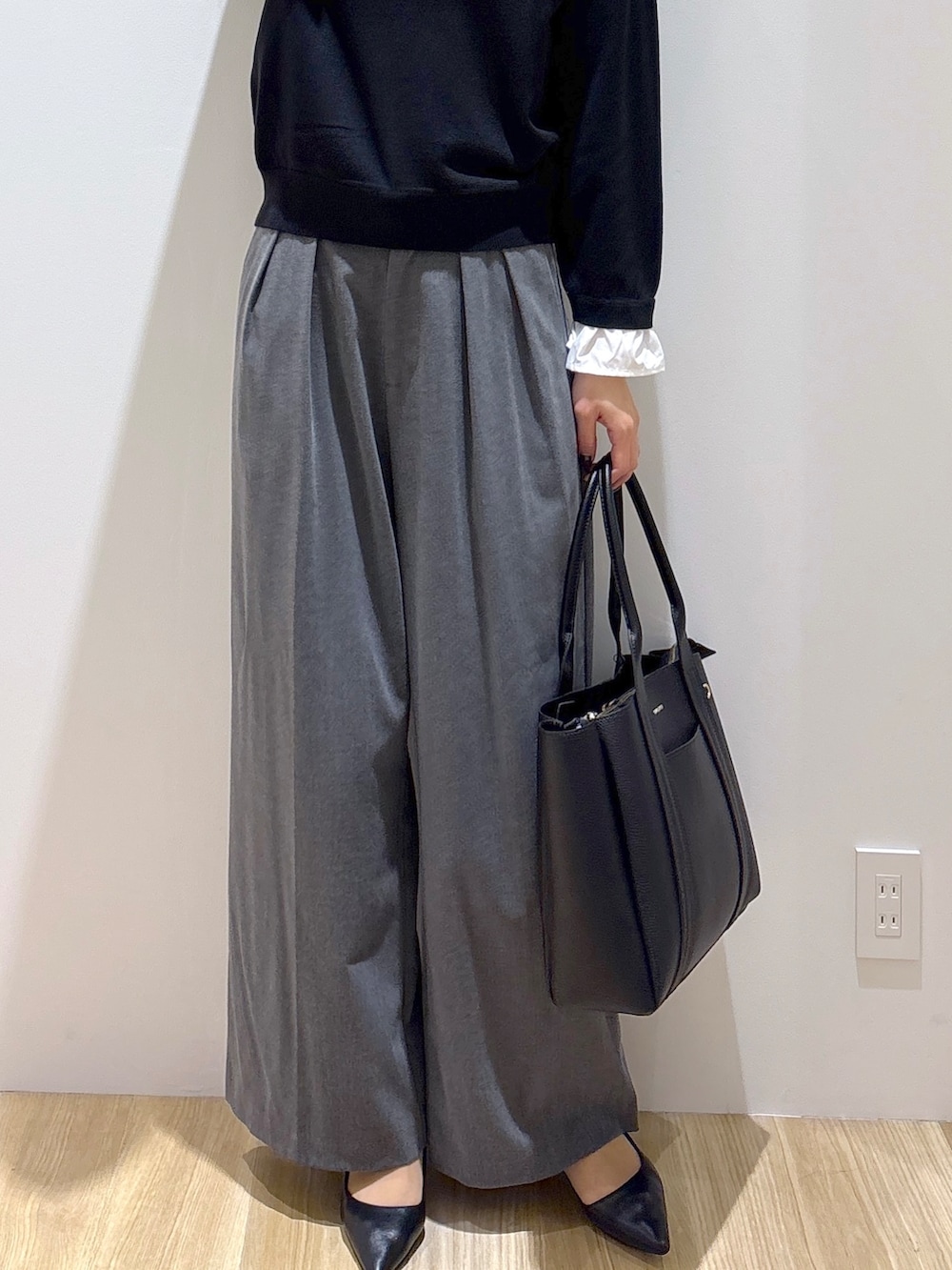 ブラック系のニット/セーター、グレー系のその他パンツ、ブラック系のトートバッグを着用したレディースの秋コーディネートの7枚目の写真