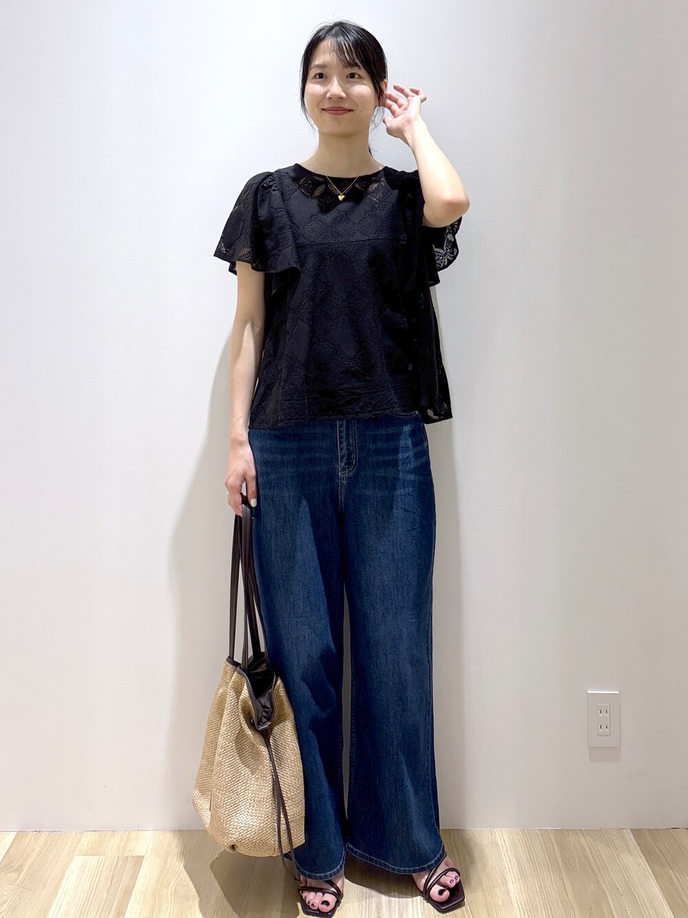 ブラック系のシャツ/ブラウス、ブルー系のデニムパンツ、ベージュ系のトートバッグを着用したレディースの春コーディネートの2枚目の写真