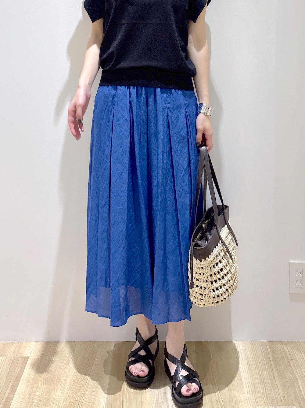 ブラック系のニット/セーター、ブルー系のその他パンツ、ブラウン系のトートバッグを着用したレディースの夏コーディネートの7枚目の写真