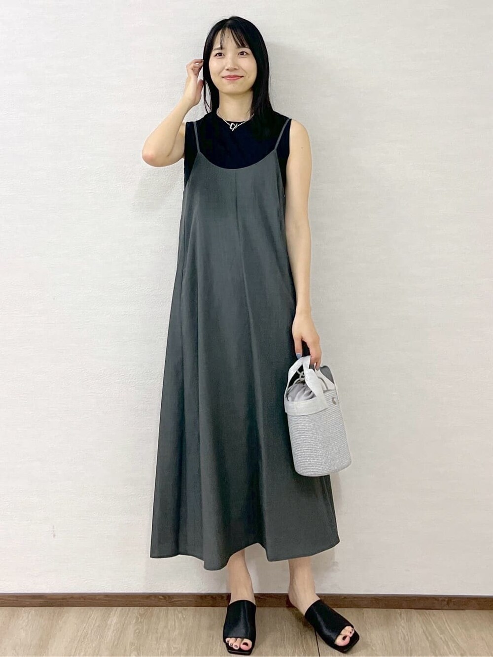 グレー系のワンピース、ブラック系のタンクトップ、シルバー系のトートバッグを着用したレディースの夏コーディネートの2枚目の写真