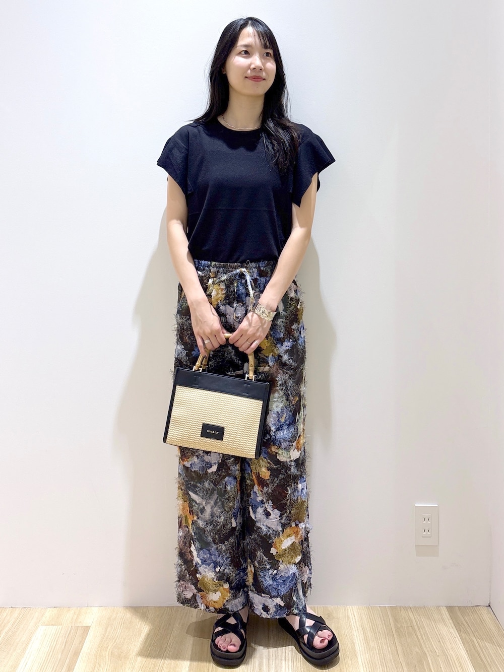 ブラック系のニット/セーター、ブラウン系のその他パンツ、ブラック系のトートバッグを着用したレディースの夏コーディネートの8枚目の写真