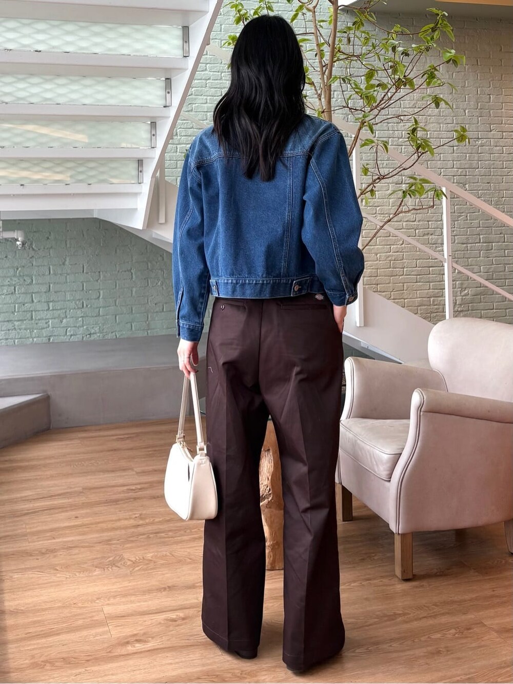 ブルー系のデニムジャケット、グレー系のニット/セーター、ブラウン系のその他パンツを着用したレディースの春コーディネートの4枚目の写真