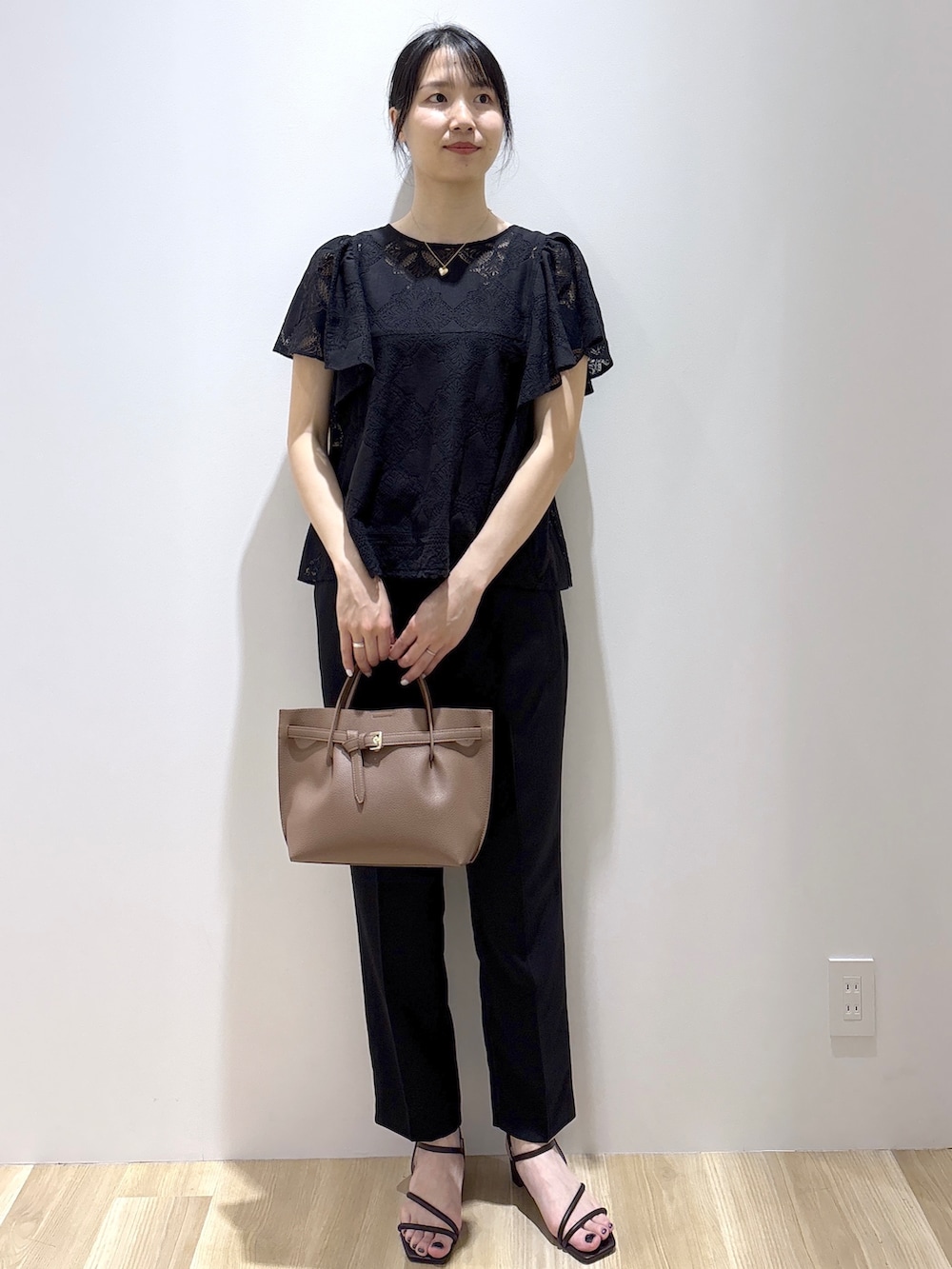 ブラック系のシャツ/ブラウス、ブラック系のその他パンツ、ブラウン系のトートバッグを着用したレディースの春コーディネートの2枚目の写真