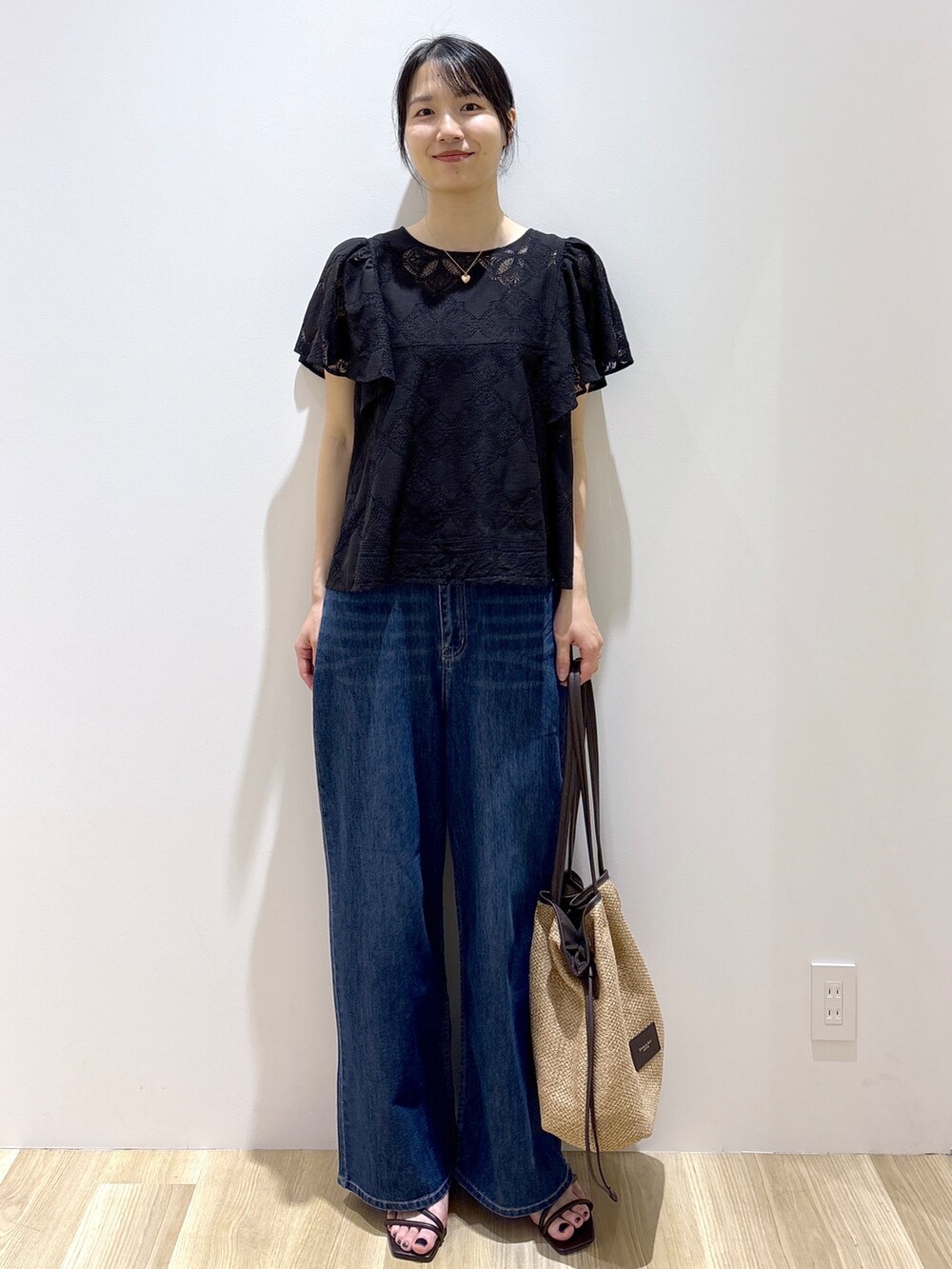 ブラック系のシャツ/ブラウス、ブルー系のデニムパンツ、ベージュ系のトートバッグを着用したレディースの春コーディネートの9枚目の写真