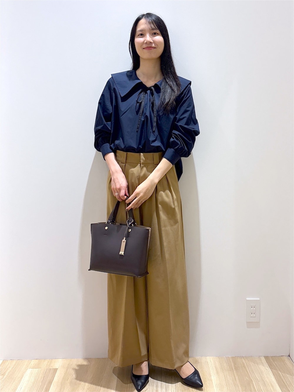 ブルー系のシャツ/ブラウス、イエロー系のその他パンツ、ブラウン系のトートバッグを着用したレディースの秋コーディネートの9枚目の写真