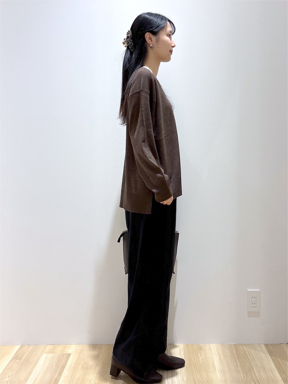 ブラウン系のニット/セーター、ブラック系のその他パンツ、ブラウン系のトートバッグを着用したレディースの秋コーディネートの5枚目の写真