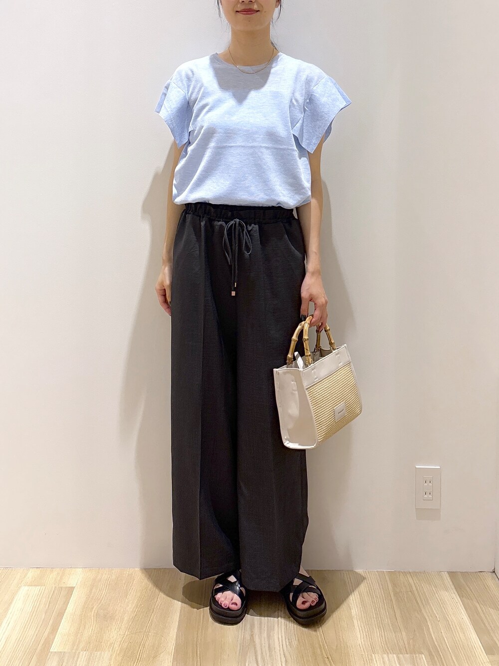 ブルー系のニット/セーター、グレー系のその他パンツ、ホワイト系のトートバッグを着用したレディースの夏コーディネートの8枚目の写真