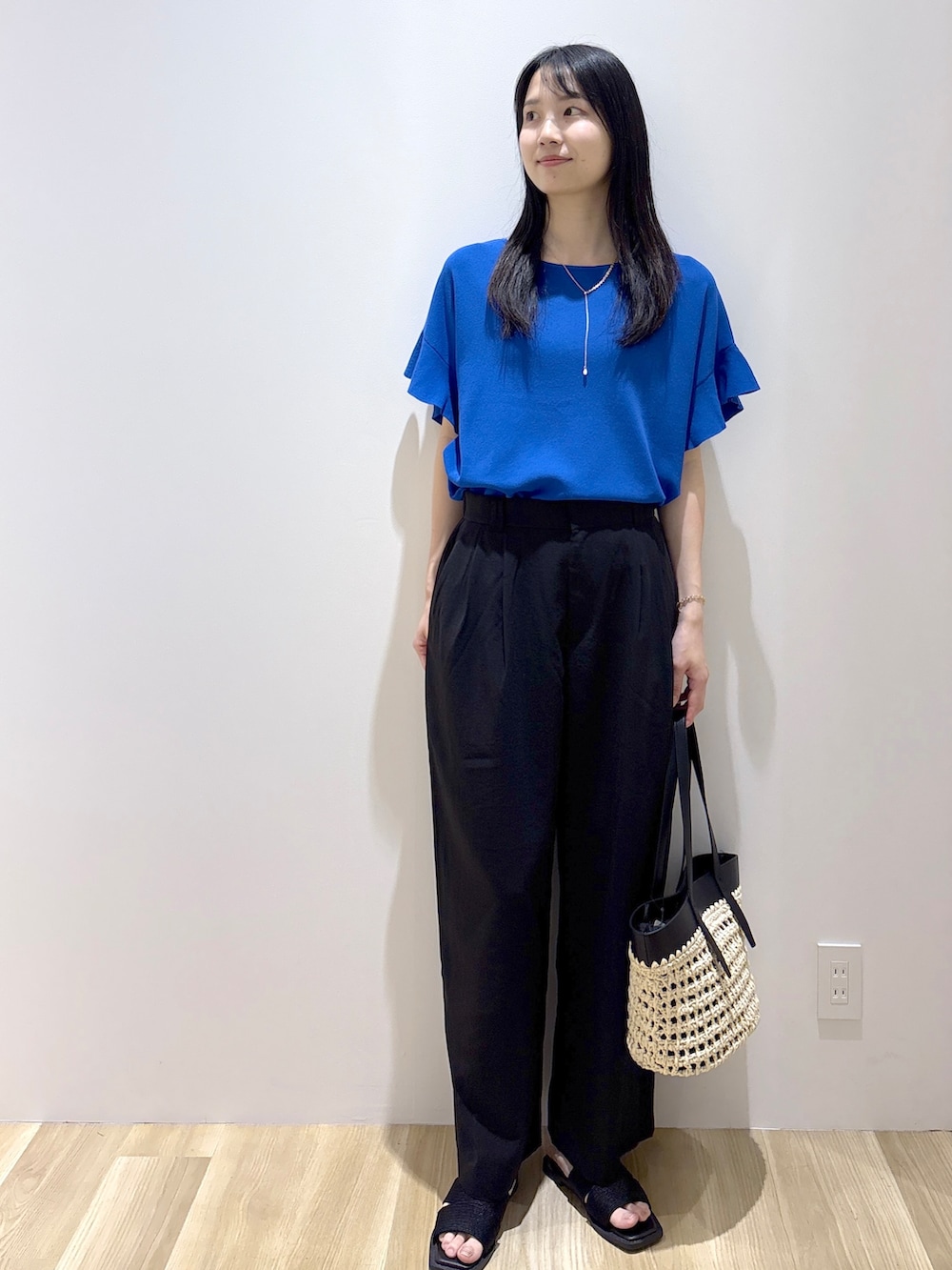 ブルー系のニット/セーター、ブラック系のその他パンツ、ブラック系のトートバッグを着用したレディースの夏コーディネートの9枚目の写真