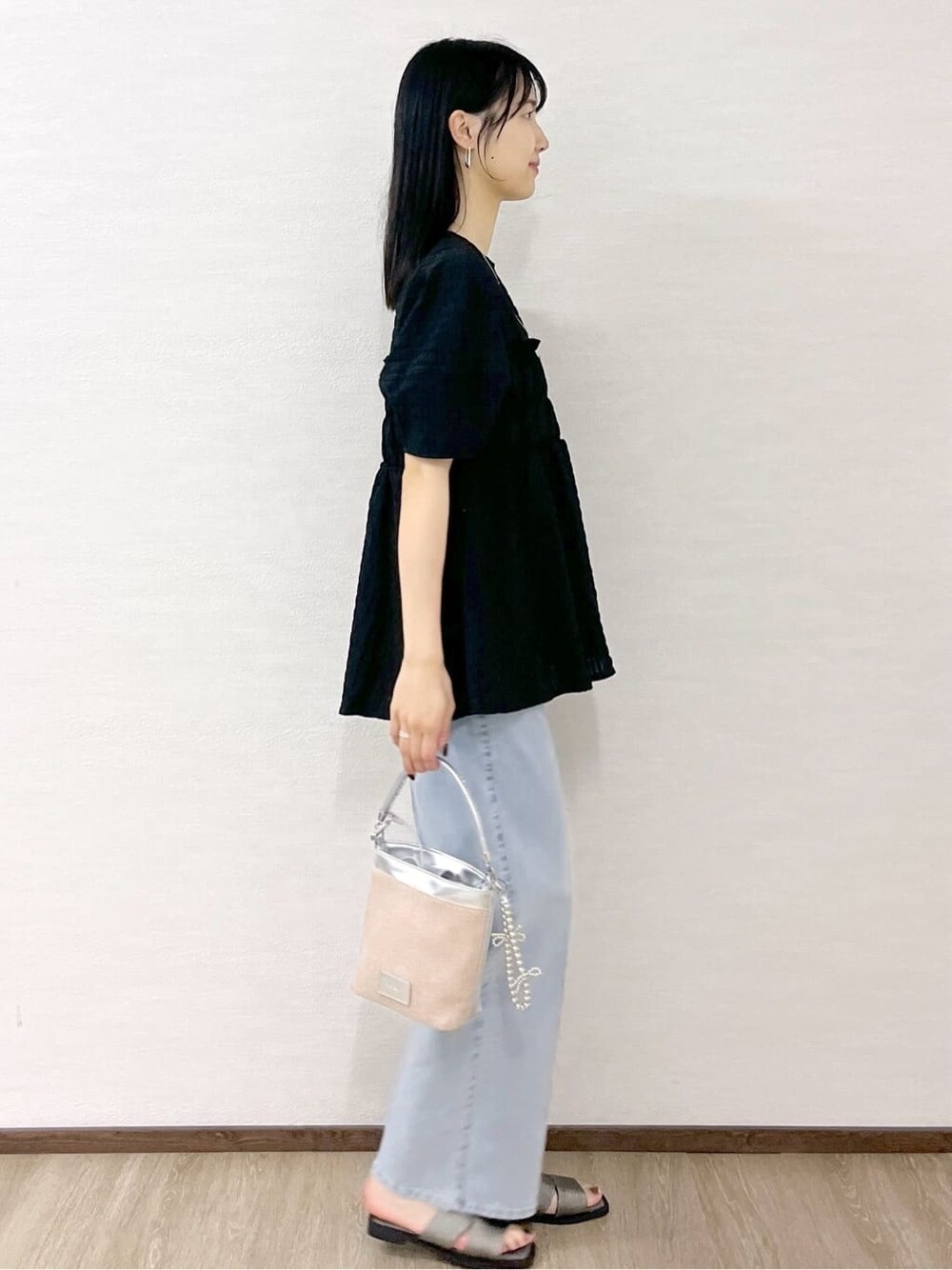 ブラック系のシャツ/ブラウス、ブルー系のデニムパンツ、シルバー系のショルダーバッグを着用したレディースの春コーディネートの7枚目の写真
