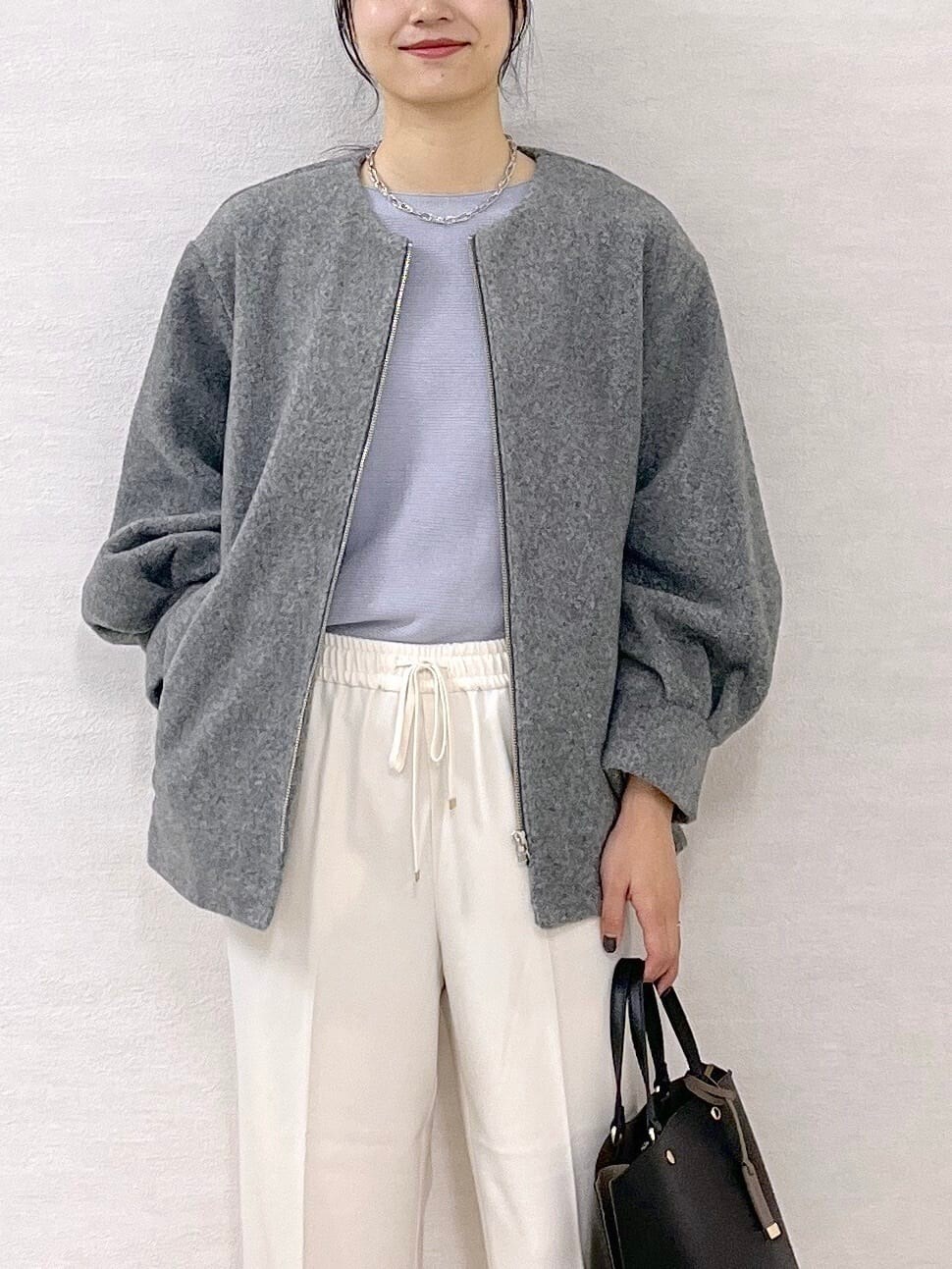グレー系のノーカラーコート、ブルー系のニット/セーター、ホワイト系のその他パンツを着用したレディースの秋コーディネートの5枚目の写真