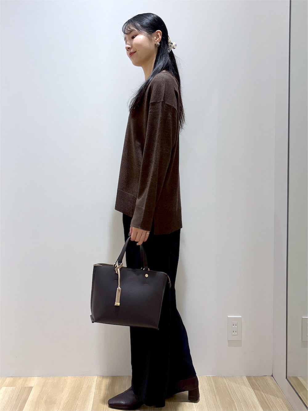 ブラウン系のニット/セーター、ブラック系のその他パンツ、ブラウン系のトートバッグを着用したレディースの秋コーディネートの3枚目の写真