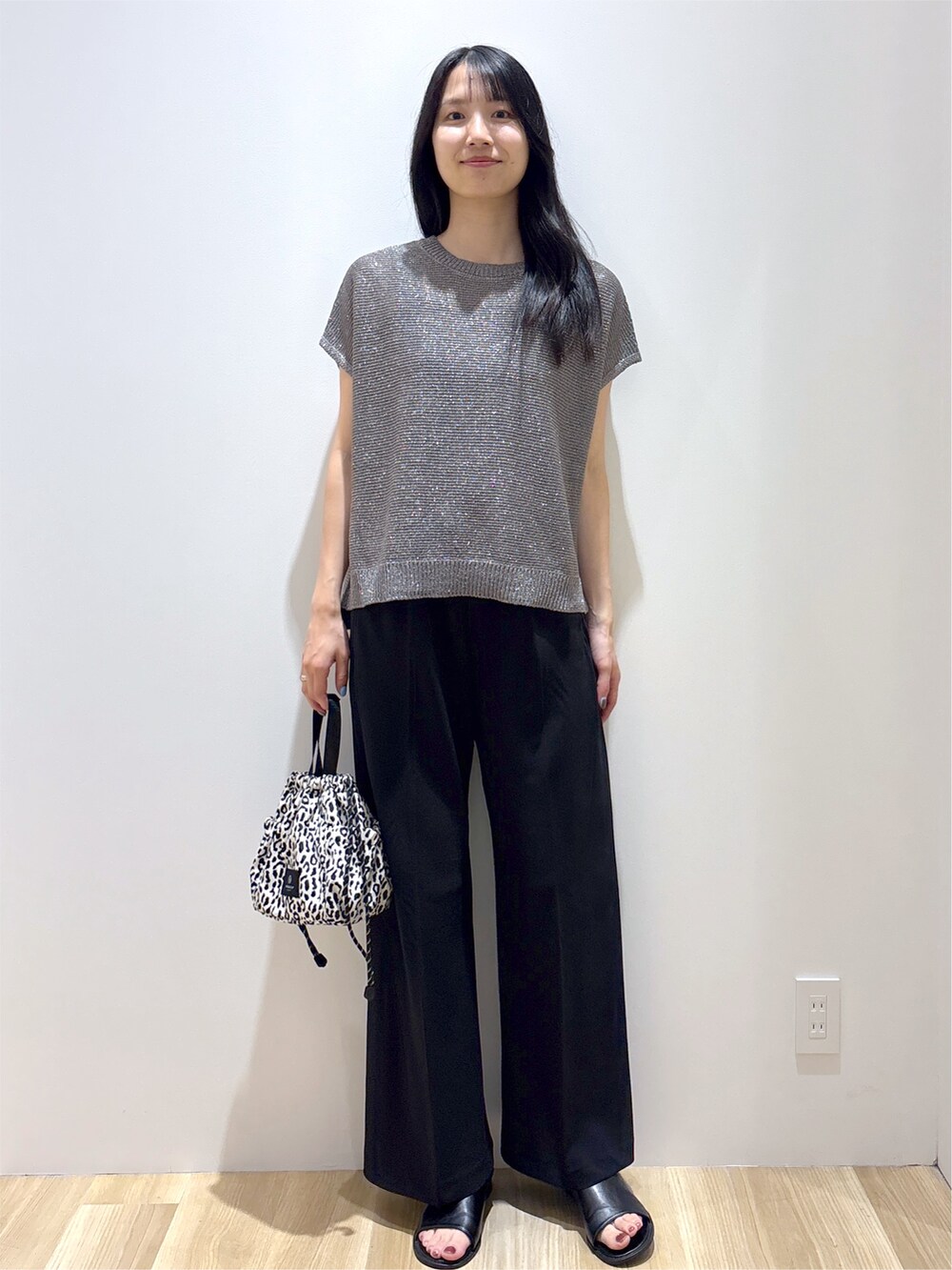 グレー系のニット/セーター、ブラック系のその他パンツ、ベージュ系のショルダーバッグを着用したレディースの夏コーディネートの8枚目の写真