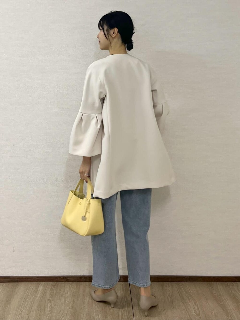 ホワイト系のノーカラーコート、ブルー系のニット/セーター、ブルー系のその他パンツを着用したレディースの冬コーディネートの4枚目の写真