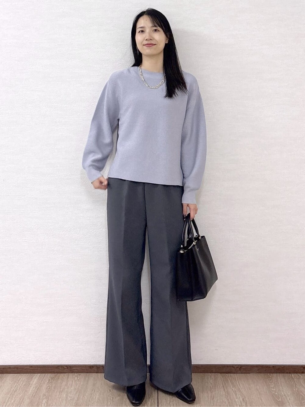ブルー系のニット/セーター、グレー系のその他パンツ、ブラック系のトートバッグを着用したレディースの冬コーディネートの8枚目の写真