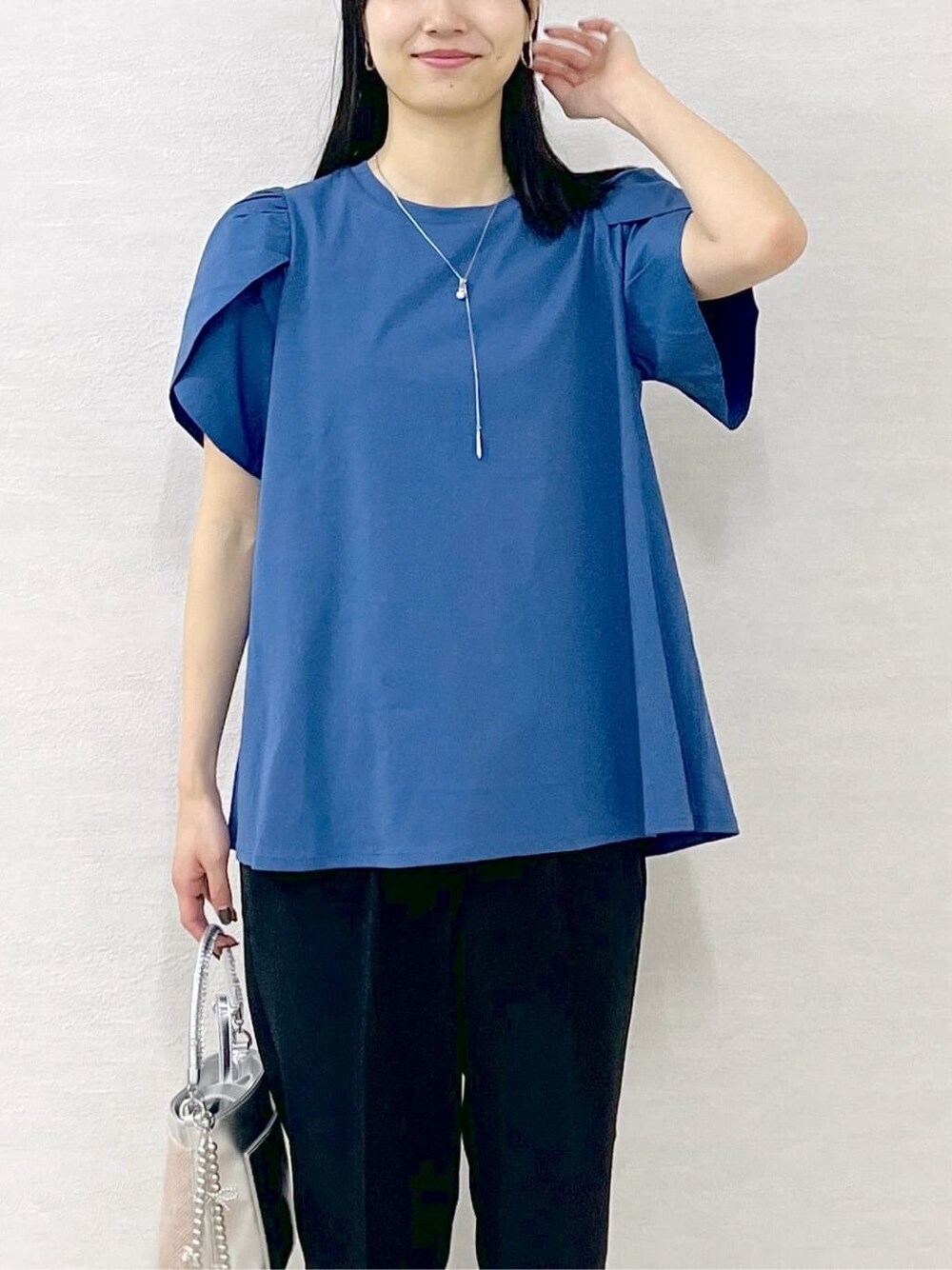 ブルー系のTシャツ/カットソー、ブラック系のその他パンツ、シルバー系のショルダーバッグを着用したレディースの春コーディネートの7枚目の写真