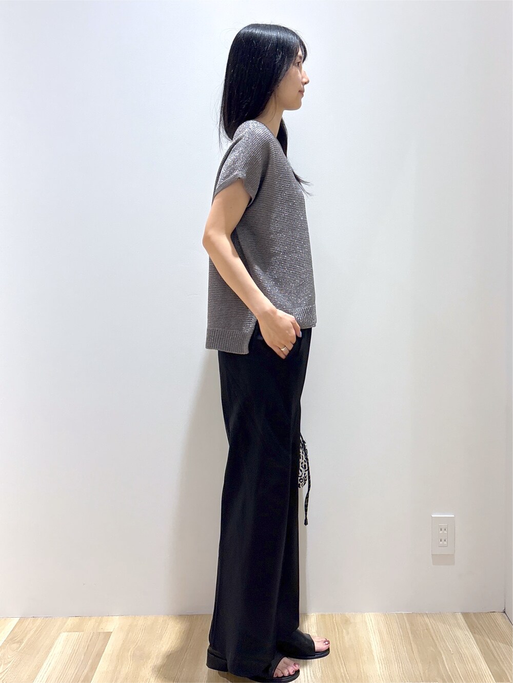 グレー系のニット/セーター、ブラック系のその他パンツ、ベージュ系のショルダーバッグを着用したレディースの夏コーディネートの5枚目の写真