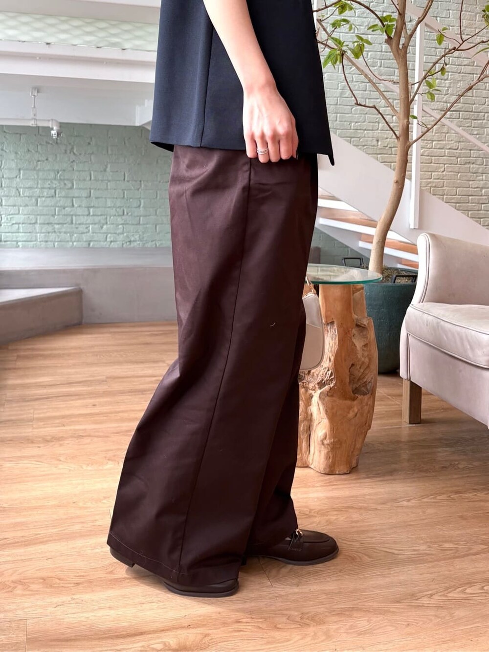 グレー系のニット/セーター、ブラウン系のその他パンツ、ホワイト系のショルダーバッグを着用したレディースの春コーディネートの7枚目の写真