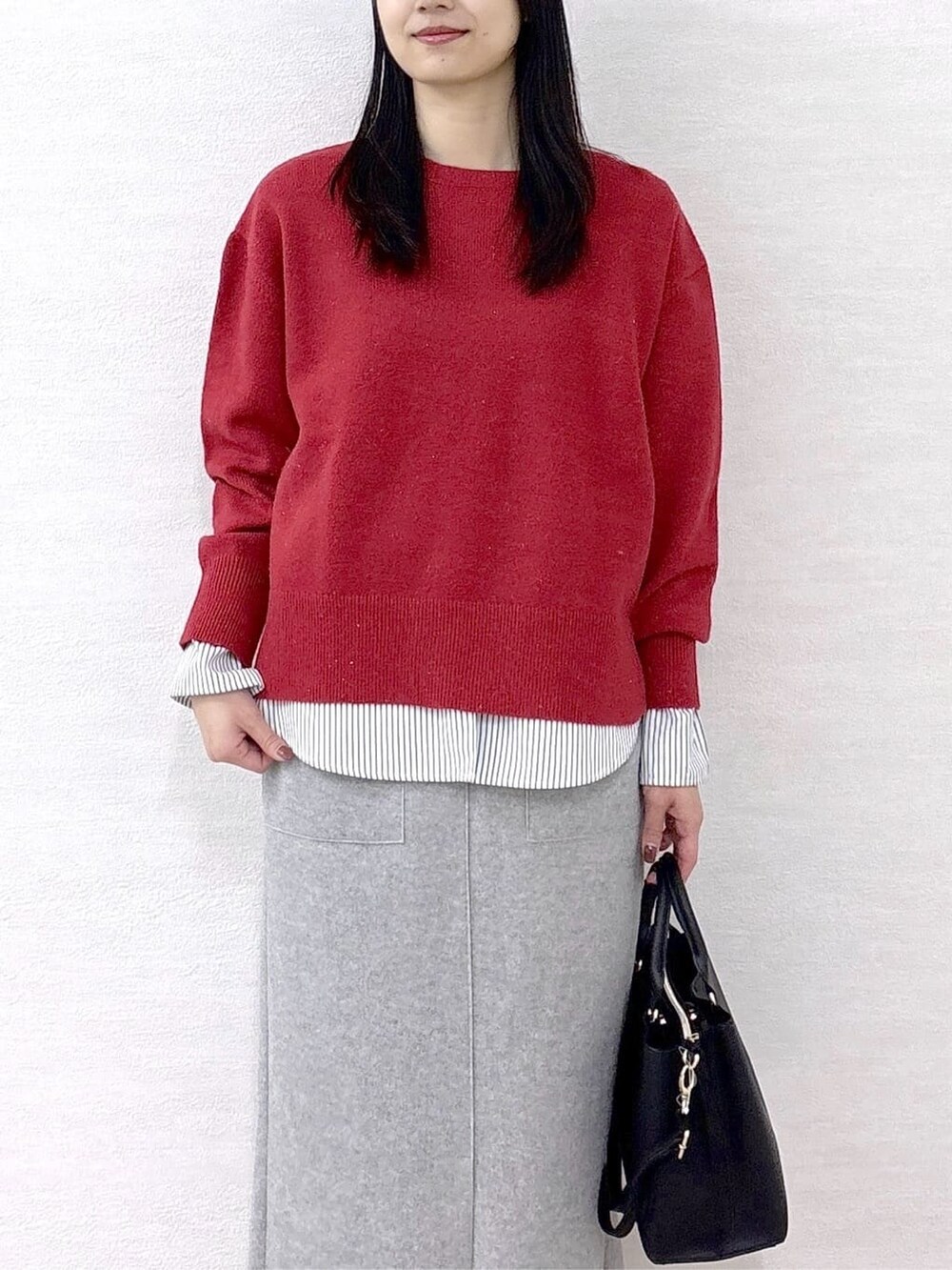 ブラック系のノーカラーコート、レッド系のニット/セーター、ホワイト系のTシャツ/カットソーを着用したレディースの冬コーディネートの8枚目の写真