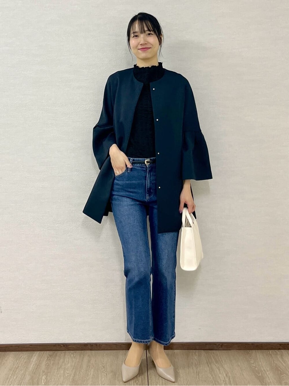 ブルー系のノーカラーコート、ブラック系のTシャツ/カットソー、ブルー系のデニムパンツを着用したレディースの冬コーディネートの9枚目の写真