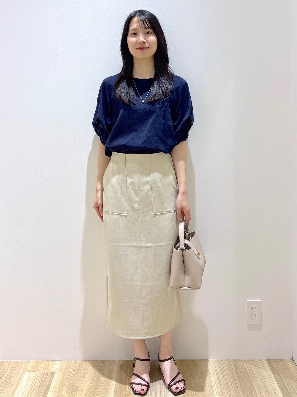 ブルー系のシャツ/ブラウス、ベージュ系のスカート、ベージュ系のハンドバッグを着用したレディースの夏コーディネートの9枚目の写真