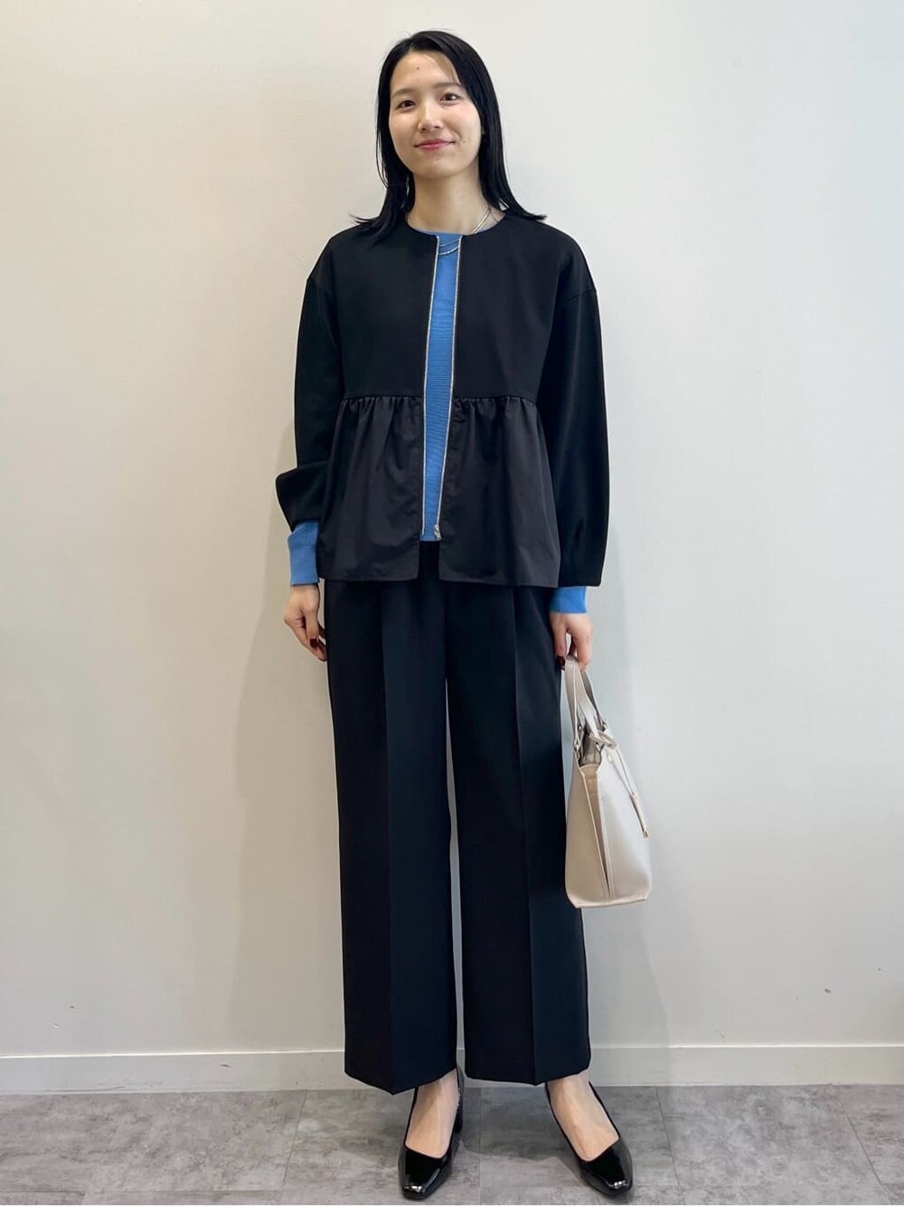 ブラック系のカーディガン/ボレロ、ブルー系のニット/セーター、ブラック系のその他パンツを着用したレディースの春コーディネートの9枚目の写真