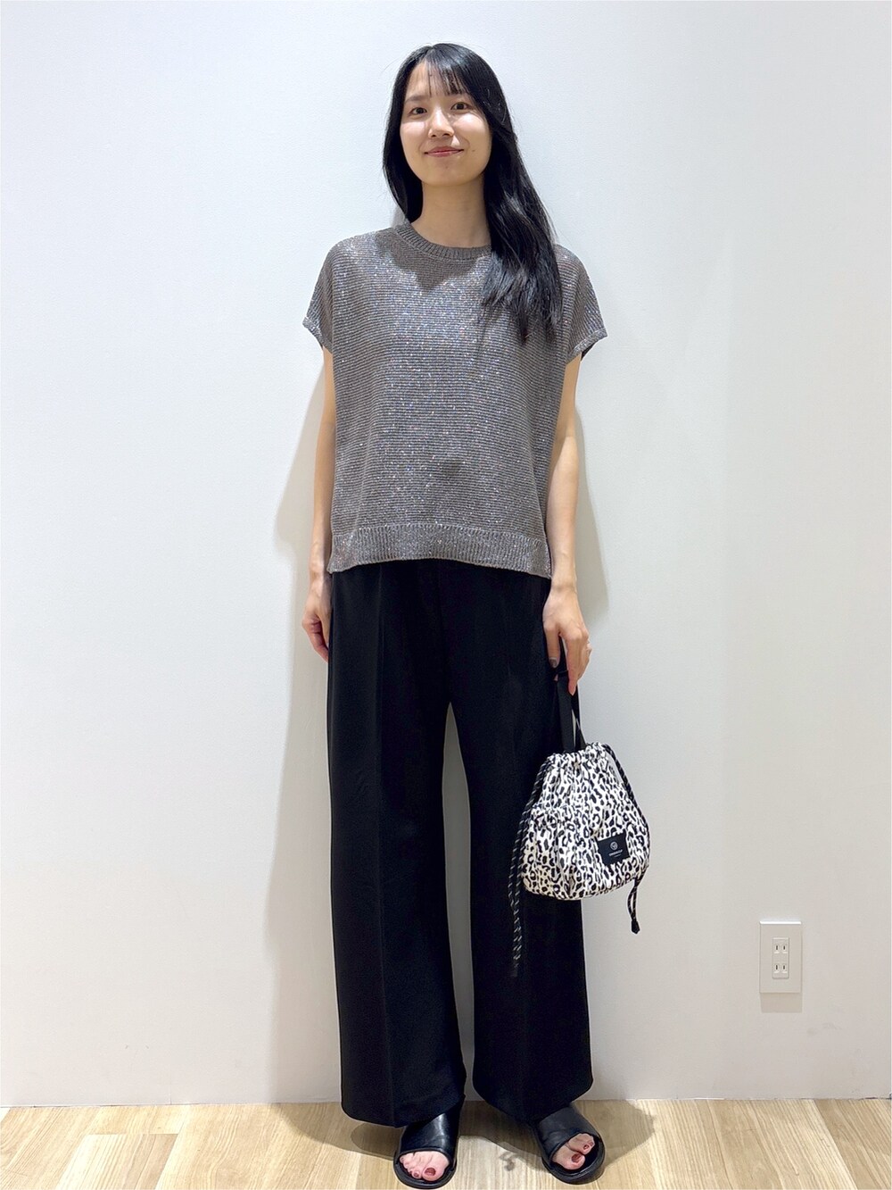 グレー系のニット/セーター、ブラック系のその他パンツ、ベージュ系のショルダーバッグを着用したレディースの夏コーディネートの10枚目の写真