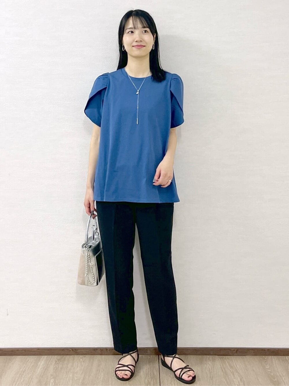 ブルー系のTシャツ/カットソー、ブラック系のその他パンツ、シルバー系のショルダーバッグを着用したレディースの春コーディネートの3枚目の写真