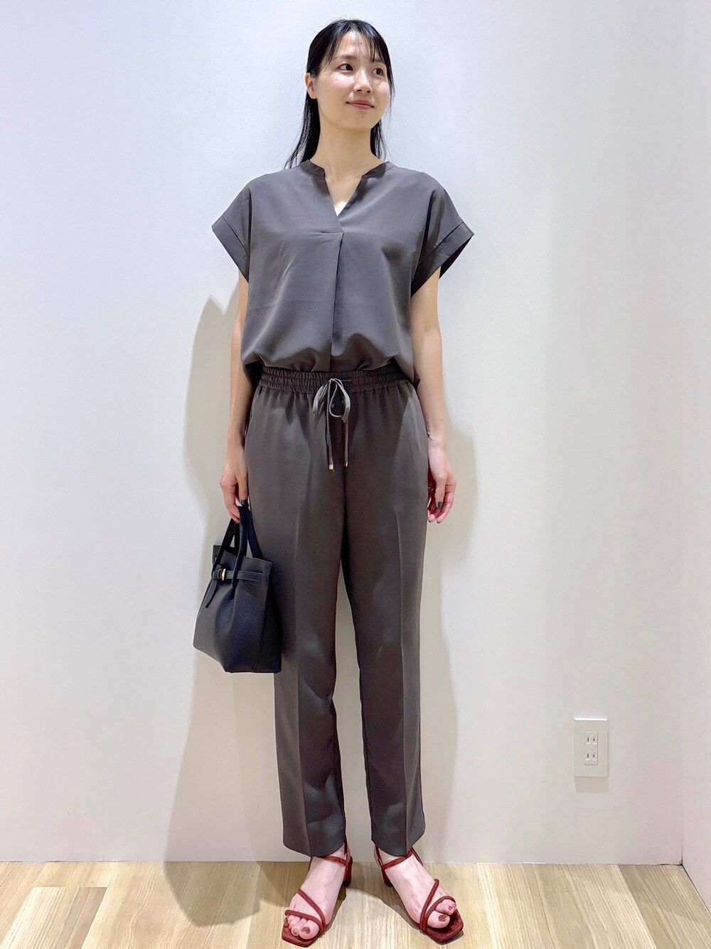 グレー系のその他パンツ、ブラック系のトートバッグ、レッド系のサンダルを着用したレディースの夏コーディネートの2枚目の写真