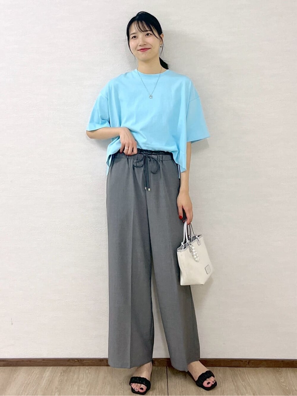 ブルー系のTシャツ/カットソー、グレー系のその他パンツ、シルバー系のトートバッグを着用したレディースの夏コーディネートの2枚目の写真