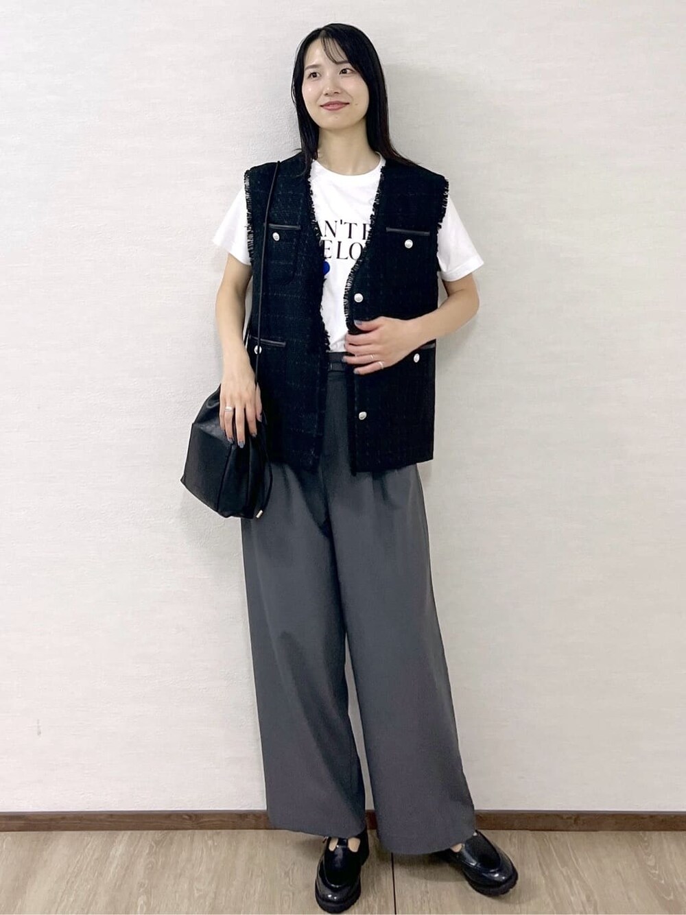 ブラック系のベスト、ホワイト系のTシャツ/カットソー、グレー系のその他パンツを着用したレディースの秋コーディネートの7枚目の写真