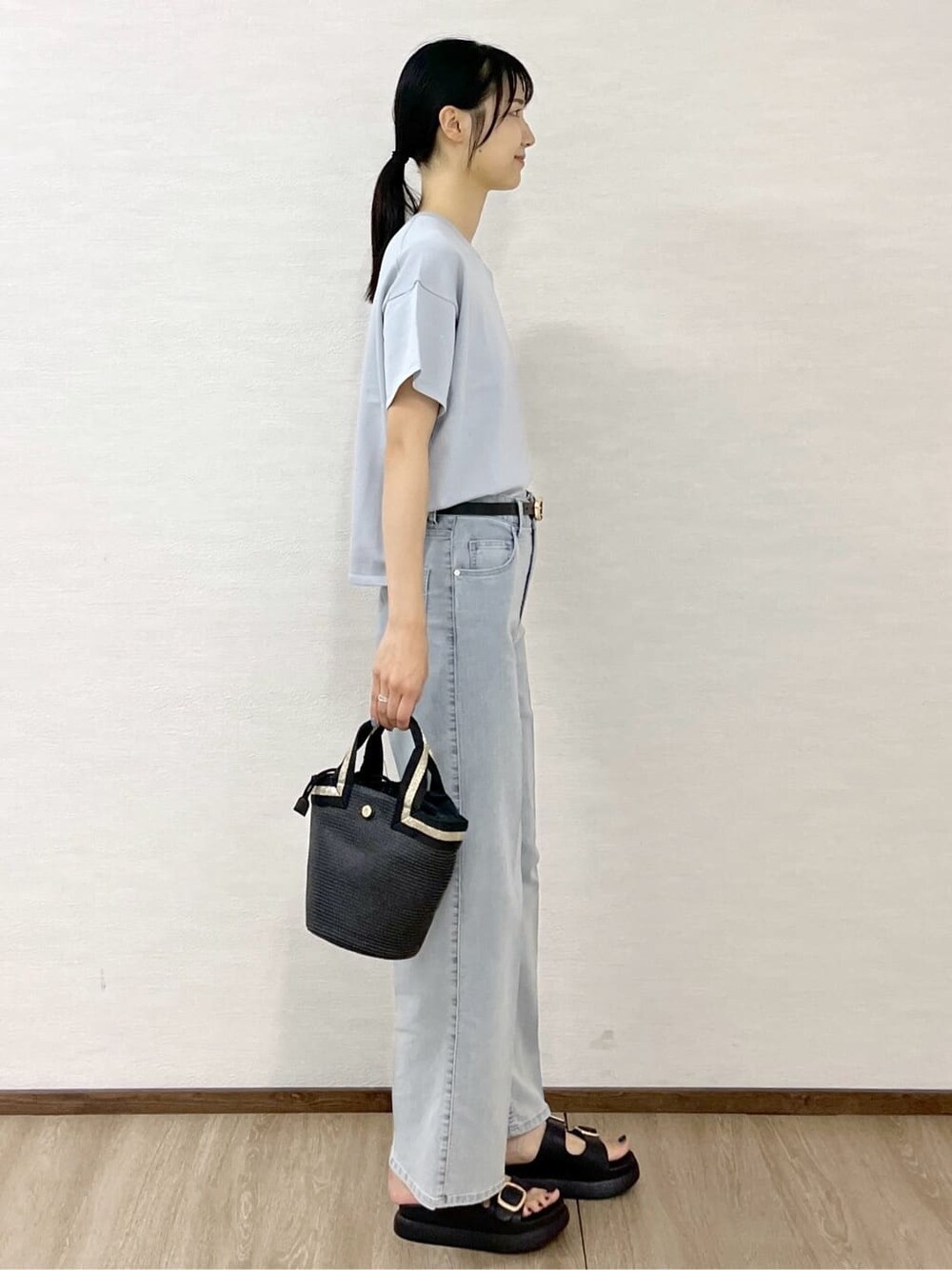 グレー系のニット/セーター、ブルー系のデニムパンツ、ブラック系のトートバッグを着用したレディースの夏コーディネートの3枚目の写真