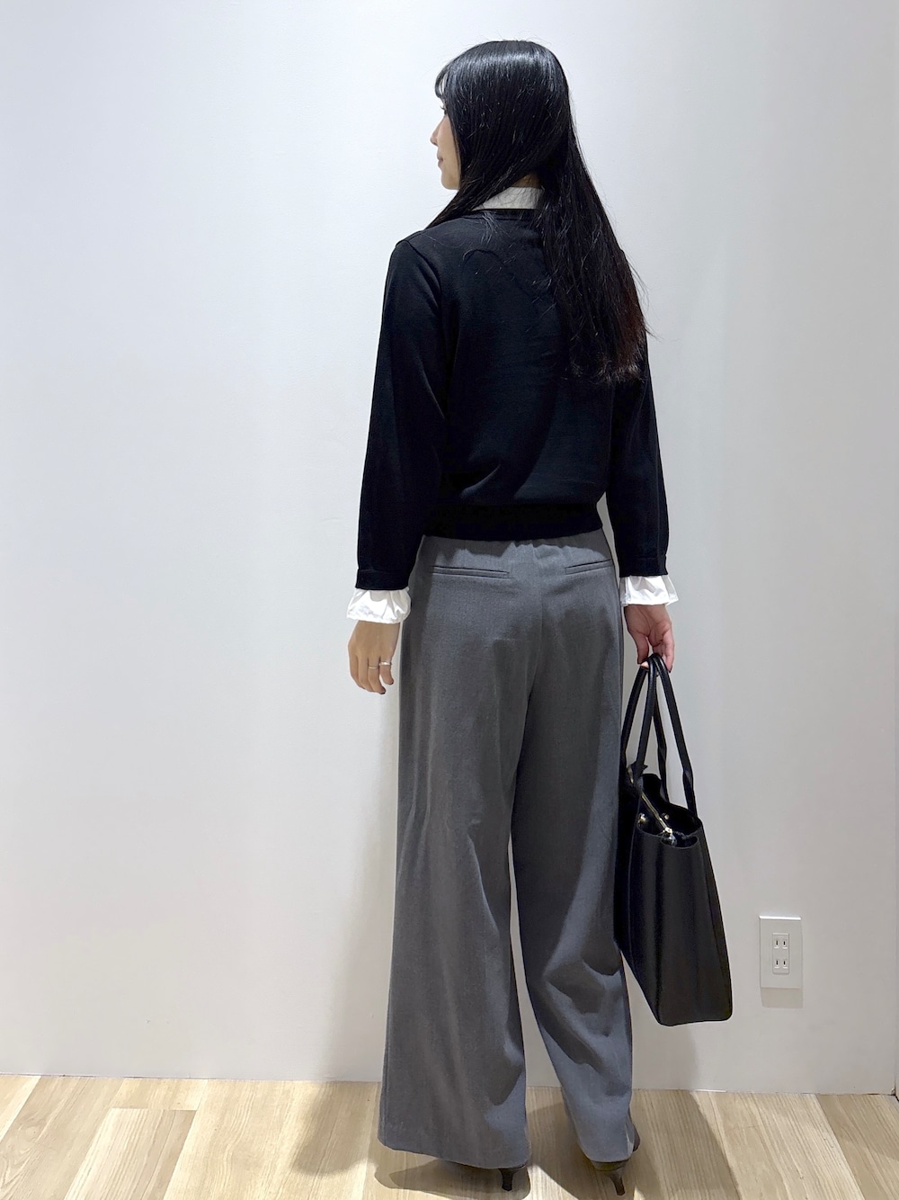 ブラック系のニット/セーター、グレー系のその他パンツ、ブラック系のトートバッグを着用したレディースの秋コーディネートの4枚目の写真