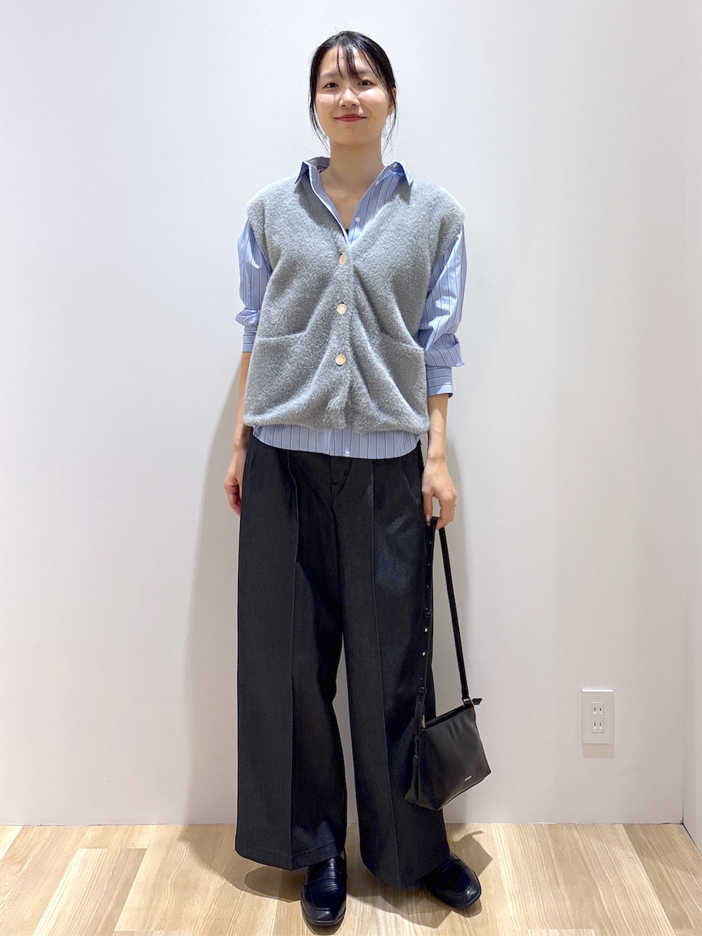グレー系のニット/セーター、ブラック系のその他パンツ、ブラック系のショルダーバッグを着用したレディースの秋コーディネートの9枚目の写真