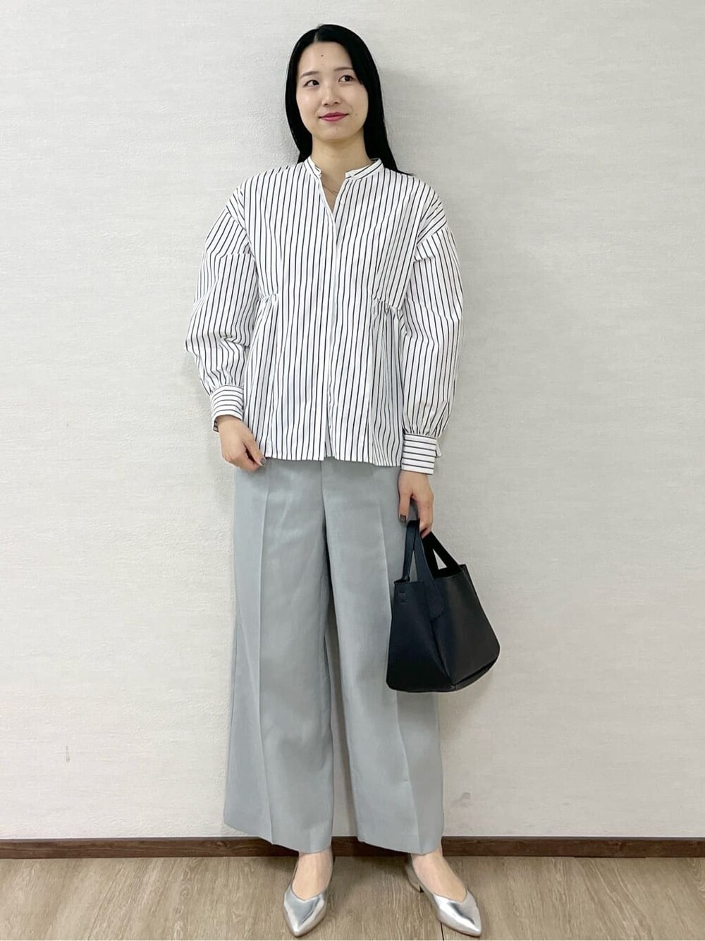 ブラック系のノーカラーコート、ホワイト系のシャツ/ブラウス、グレー系のその他パンツを着用したレディースの春コーディネートの10枚目の写真