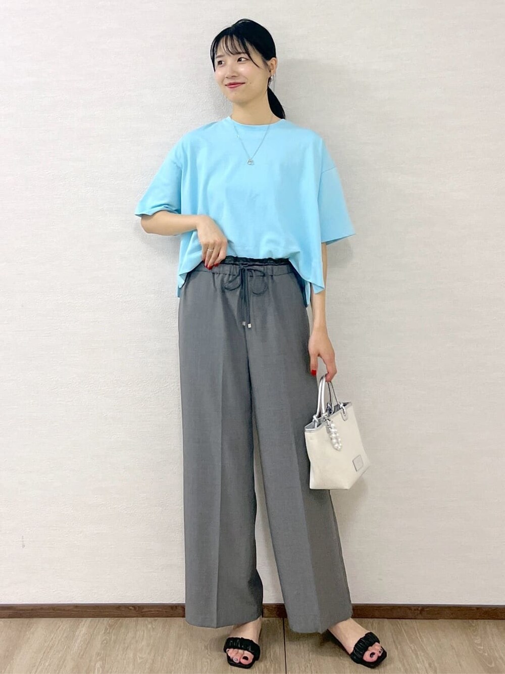 ブルー系のTシャツ/カットソー、グレー系のその他パンツ、シルバー系のトートバッグを着用したレディースの夏コーディネートの9枚目の写真