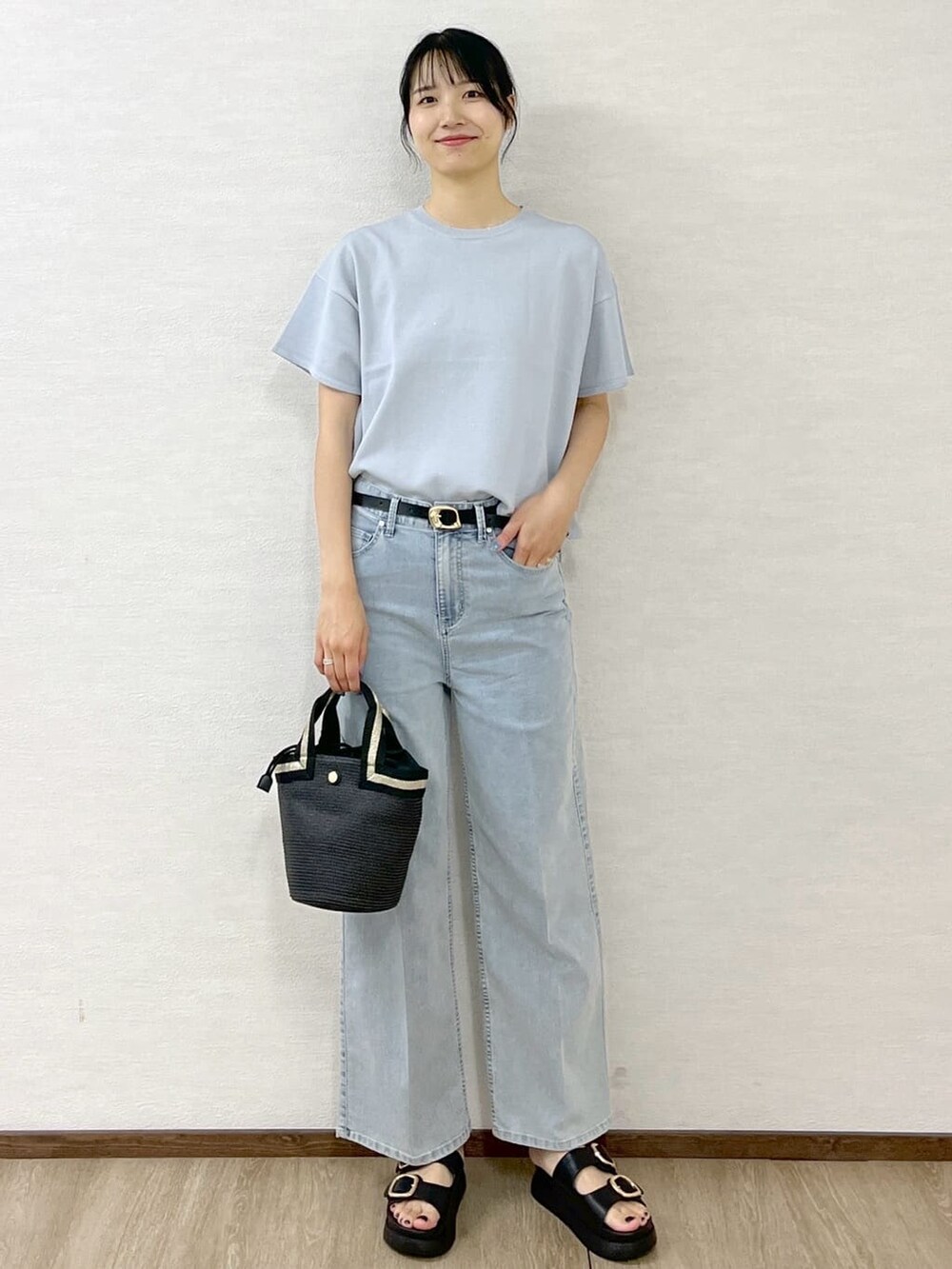 グレー系のニット/セーター、ブルー系のデニムパンツ、ブラック系のトートバッグを着用したレディースの夏コーディネートの2枚目の写真