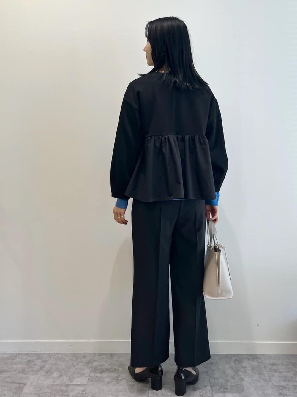 ブラック系のカーディガン/ボレロ、ブルー系のニット/セーター、ブラック系のその他パンツを着用したレディースの春コーディネートの5枚目の写真