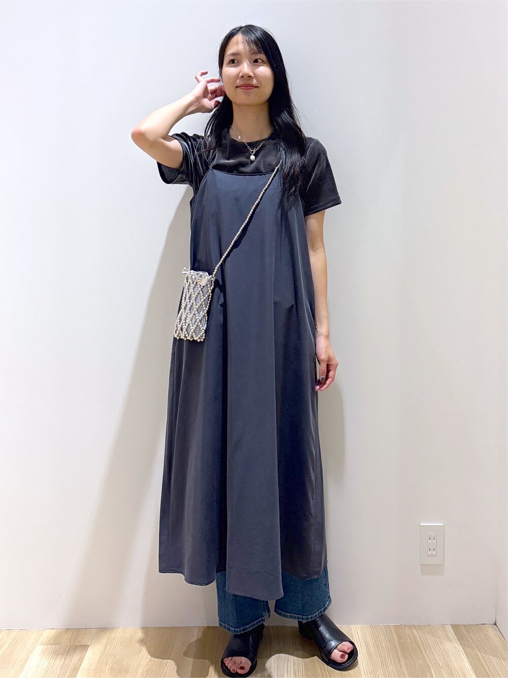 グレー系のワンピース、グレー系のTシャツ/カットソー、ブルー系のデニムパンツを着用したレディースの夏コーディネートの2枚目の写真